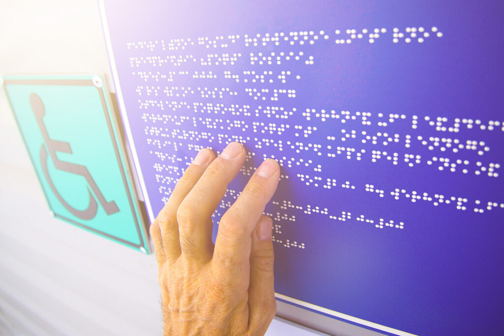 Hand reading sign in braille 