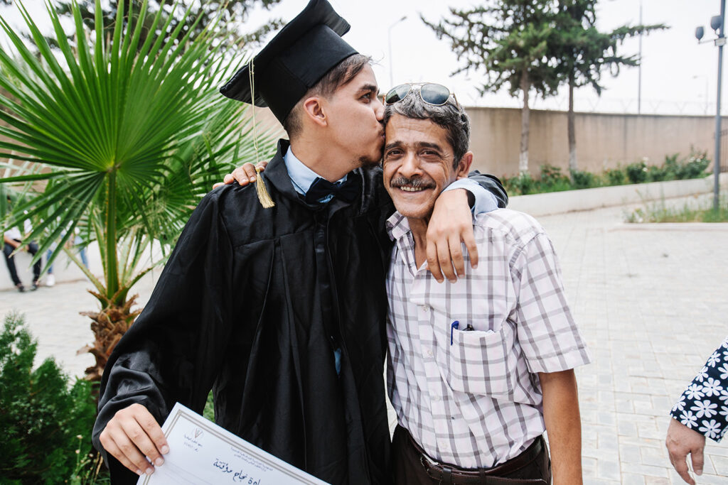 son hugging father at graduation